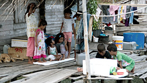 Anak Laut of Temiang island playing with whatever they can find around their huts.